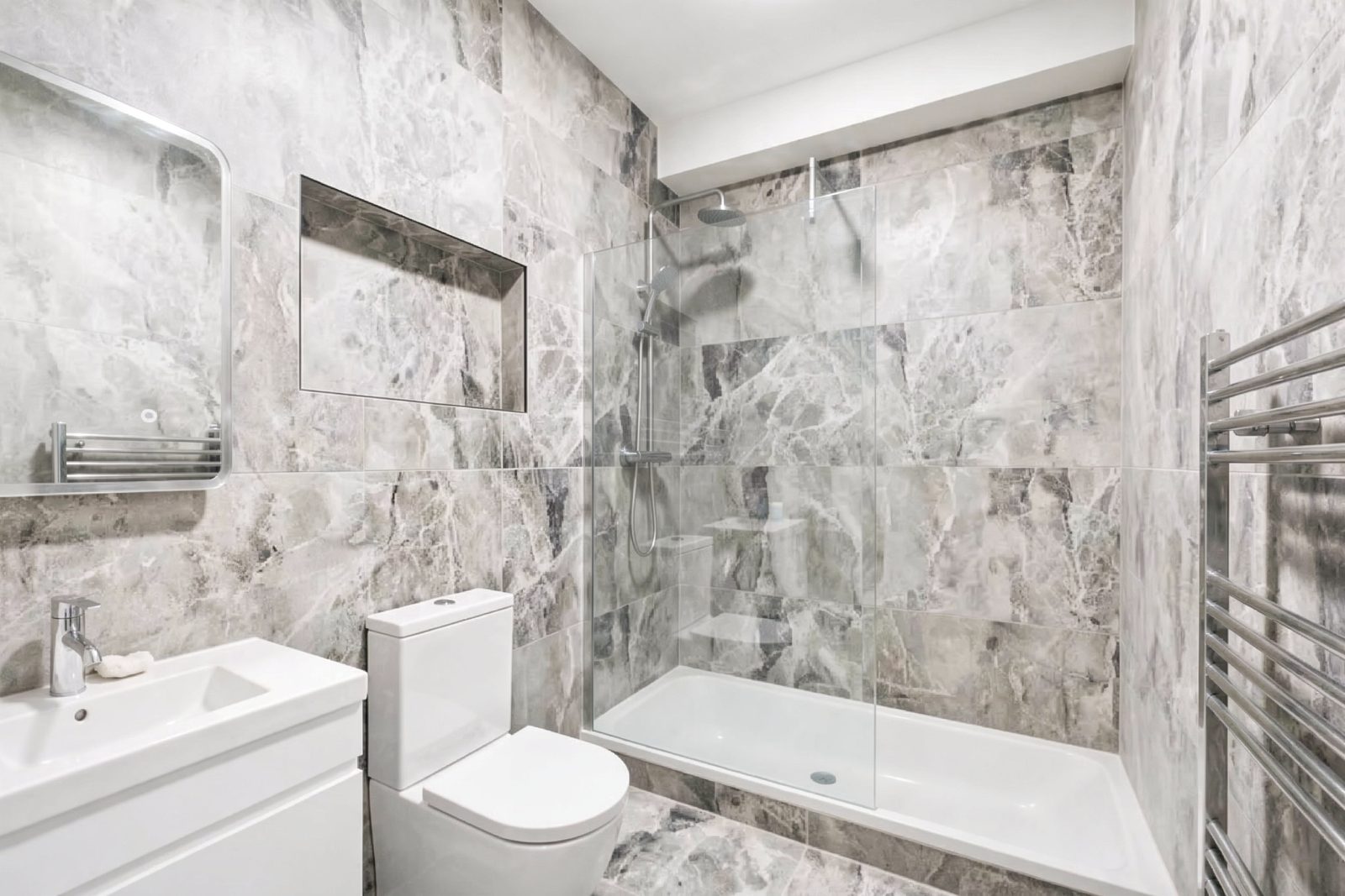 Shower room with large marble-effect tiles, a walk-in shower and a heated towel rail.